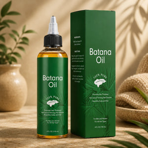 Batana Oil bottle and packaging on a wooden surface with a plant in the background