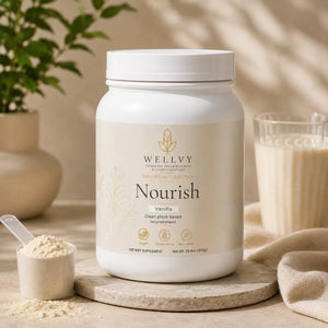 Wellyv Nourish vanilla supplement container on a wooden surface with a glass of milk and scoop of powder.